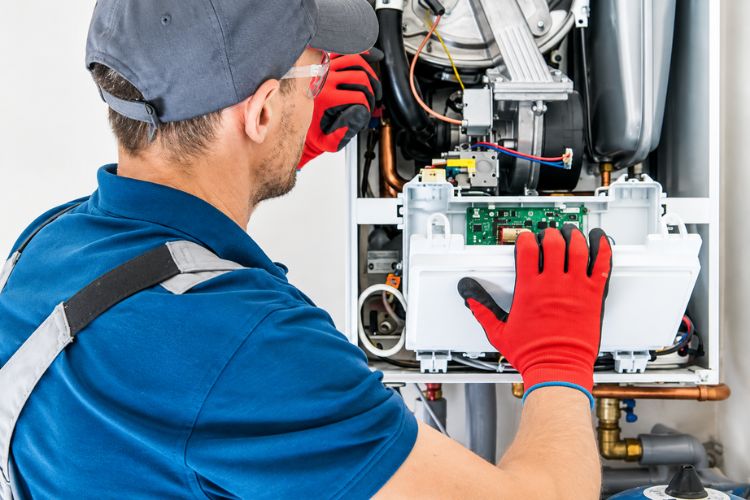 A recognized HVAC contractor working on furnace maintenance in Lenexa