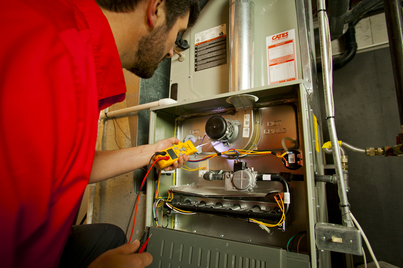 A Cates technician inspecting a furnace